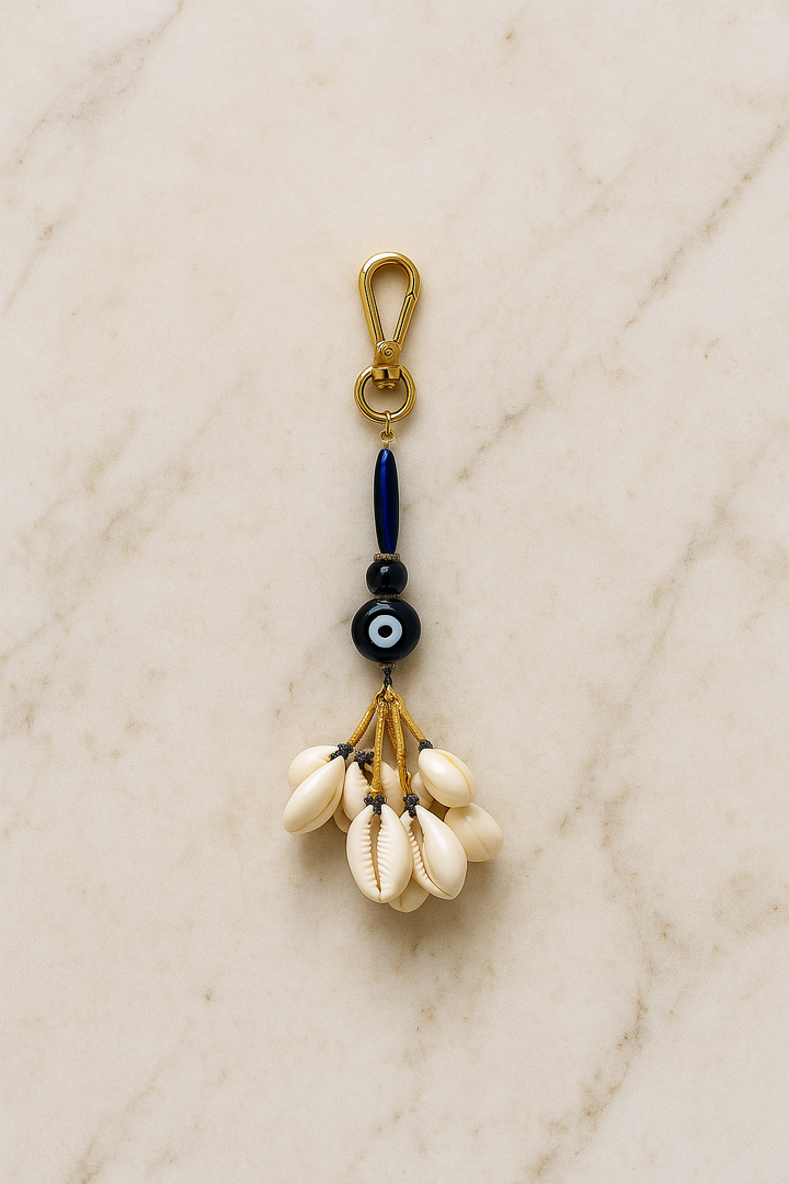 Keychain with cowrie shells and beads on a marble surface